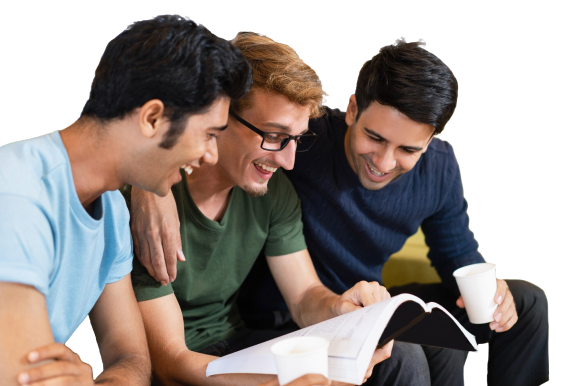 Three fellow students reading textbook laughing drinking